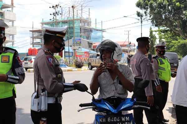 WAJIB PROTOKOL KESEHATAN : Petugas dari tim gabungan saat mendisiplinkan warga Pangkalan Bun yang kedapatan tanpa mengenakan masker.(POLRES KOBAR/RADAR PANGKALAN BUN)