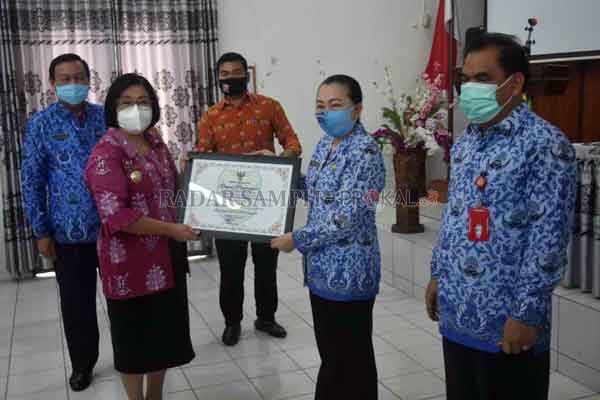 SERAHKAN: Wakil Bupati Gumas Efrensia LP Umbing didampingi Sekda Yansiterson, dan Kepala Bappedalitbang Yantrio Aulia menyerahkan piagam penghargaan kepada Dinas Komunikasi, Informatika, Persandian, dan Statistik yang berhasil meraih juara pertama lomba i