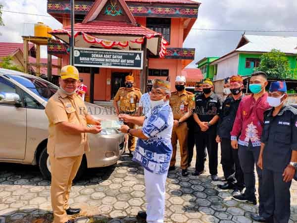 BANTUAN: Sekda Kotim Halikinnor saat menyerahkan bantuan mobil operasional untuk Dewan Adat Dayak (DAD) Kotim, yang diterima langsung oleh Ketua DAD Kotim Untung TR di halaman kantor DAD Kotim Jalan Ahmad Yani, Selasa (22/9).(YUNI/RADAR SAMPIT)