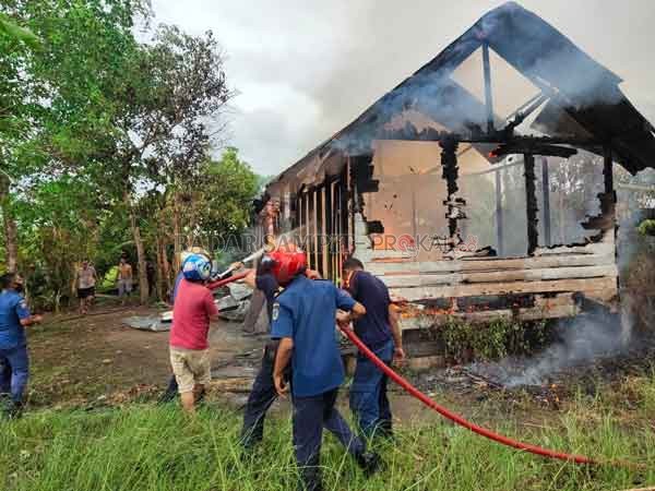 KERJA KERAS: Petugas pemadam kebakaran dibantu warga harus berjuang keras memadamkan api yang melumat kediaman Rahimah, Selasa (22/9).(HENDRI/RADAR SAMPIT)