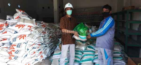 Kepala Tata Usaha PT Musirawas Citraharpindo menyerahkan bantuan beras kepada Kepala Desa Asam Baru, Kecamatan Danau Seluluk