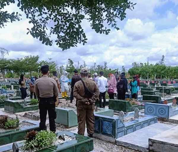 RAWAN PENULARAN: Petugas kepolisian bersama tim satgas covid-19 saat melakukan pengawalan pemakaman salah satu masyarakat di TPU Muslimin kilometer  12 dengan penerapan protokol kesehatan, kemarin.(istimewa)