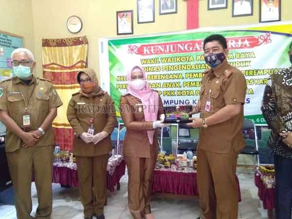 SERAHKAN: Wakil Walikota Palangka Raya Umi Mastikah menyerahkan pelakat kenang – kenangan kepada Pj Sekda Kotim Suparmadi, pada kegiatan kunjungan di kampung KB Kotim, Selasa (6/10).(IST/RADARSAMPIT)