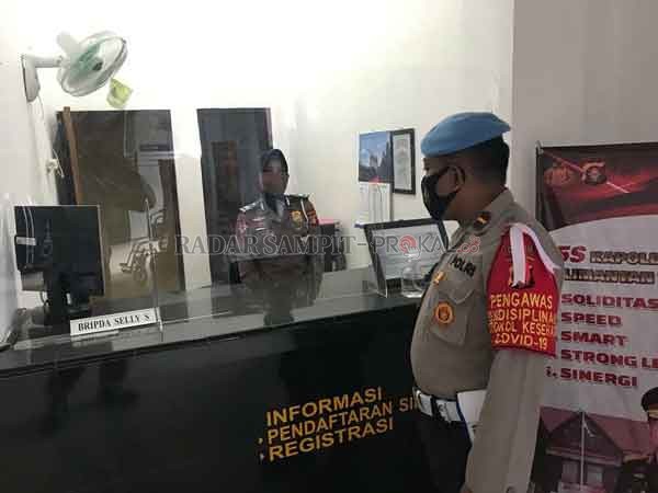 PEMANTAUAN : Petugas propam Polresta Palangka Raya, saat memantau pelayanan di jajaran Satlantas Polresta palangka raya terkait pembuatan SIM. (IST/RADARPALANGKA)