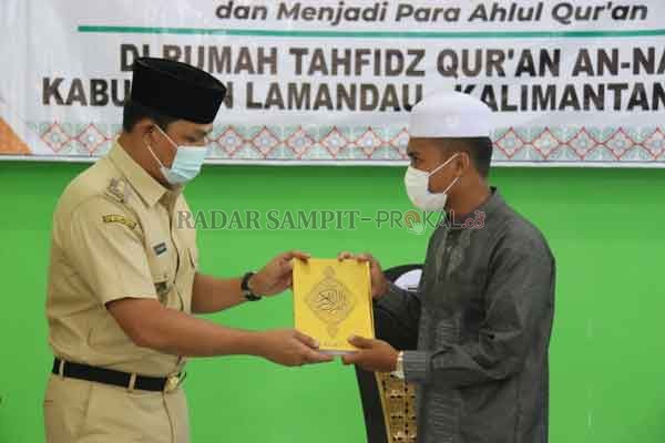 RUMAH TAHFIDZ : Bupati Lamandau Hendra Lesmana menyerahkan Alquran kepada salah satu santri Rumah Tahfidz Qur