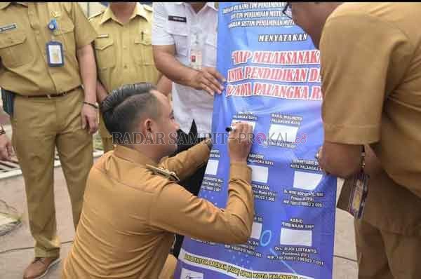 KOMITMEN : Wali Kota Palangka Raya Fairid Naparin sebelum pandemi menandatangani komitmen untuk terus mewujudkan pelaksanaan sistem penjamin mutu pendidikan sekolah sekaligus menyerahkan dana penunjang sekolah.(DOK/HUMAS PEMKO PALANGKA RAYA)