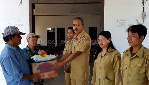 BANTUAN : Kades Sambi Kholidin secara simbolis menerima bantuan dari Kelompok IPR Sehat Bersatu, Selasa (20/10).(ISTIMEWA/RADAR PANGKALAN BUN)