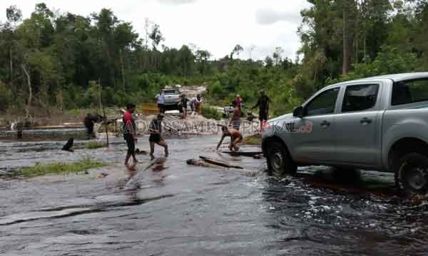 JALAN PUTUS : Warga saat melakukan evakuasi terhadap mobil yang melintas di jalan putus akibat banjir.(IST/RADARSAMPIT)