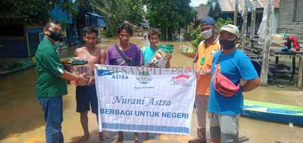 BANTUAN BANJIR : CDO PT.GSDI-GSYM M.Hayatun Ridwan menyerahkan bantuan secara simbolis kepada warga terdampak banjir di Desa Nangamua, Kecamatan Arut Utara disaksikan Kepala Desa Heriyanto.(ISTIMEWA/RADAR PANGKALAN BUN)