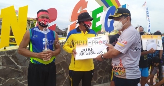 APRESIASI: Ketua DPRD Kobar Rusdi Gozali saat menyerahkan hadiah kepada salah satu pemenang lomba dayung di Kampung Sega, Pangkalan Bu, Minggu (25/10). (RINDUWAN /RADAR PANGKALAN BUN)