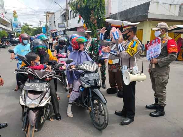 OPERASI ZEBRA : Kasatlantas Polres Kotim sambil membawa toa (pengeras suara) memberikan edukasi kepada pengendara agar tertib berlalu lintas serta mematuhi protokol kesehatan di kawasan Pusat Perbelanjaan Mentaya (PPM), Sampit, Kamis (29/10) pagi kemarin.