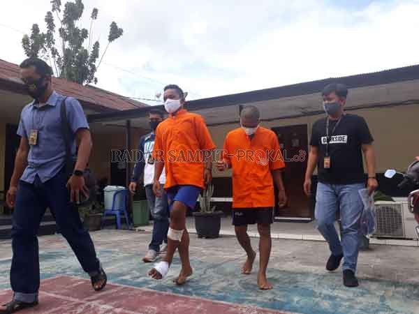TERSANGKA : Ahmad Yudha Pratama (21) berjalan pincang setelah ditembak di bagian kaki,  terlihat saat bersama Rahmad Hidayat (26) saat digiring petugas.(DODI/RADAR PALANGKA)