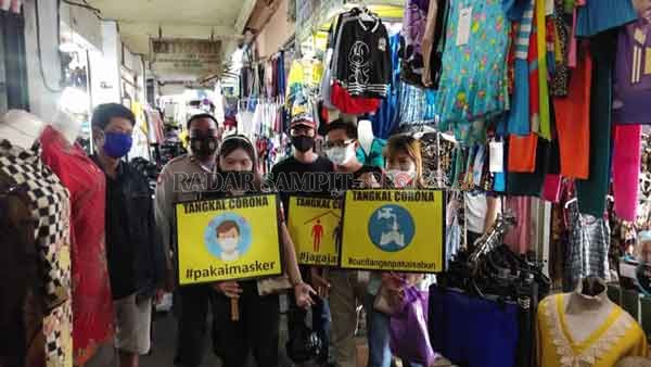 SOSIALISASI :Sejumlah warga di Palangka Raya, ketika diminta petugas untuk turut mengkampanyekan tulisan yang mengajak penerapan protokol kesehatan, baru-baru tadi.(istimewa)