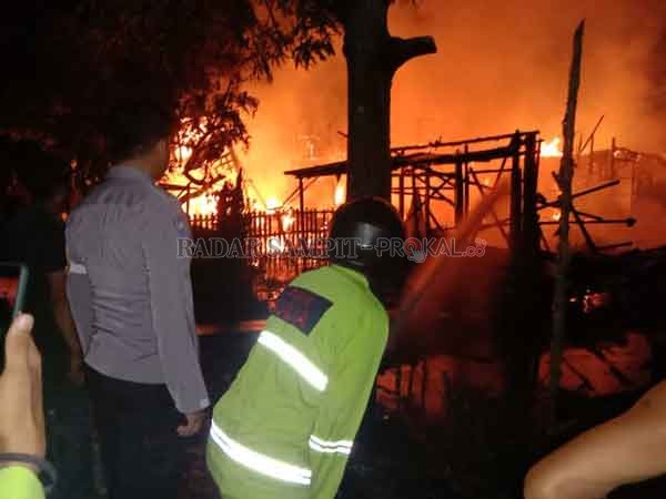 KEBAKARAN : Warga bersama regu pemadam kebakaran dan personel kepolisian melakukan pemadaman rumah yang terbakar di Desa Tatas Hilir, Pulau Petak, Kapuas, Selasa (14/12) malam.(ALEXANDER/RADAR SAMPIT)