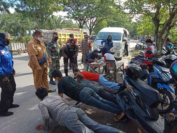 SANKSI: Warga yang terjaring operasi yustisi di data dan diberikan sanksi push up di tempat, mereka diminta disiplin dalam memakai masker saat beraktivitas selama pandemi ini.(IST/RADARSAMPIT)