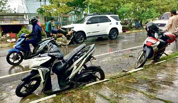 KECELAKAAN : Mobil Fortuner putih yang rusak akibat menabrak kendaraan yang parkir dan menabrak plankson jalan Selasa (29/12).(Rinduwan /Radar Pangkalan Bun )