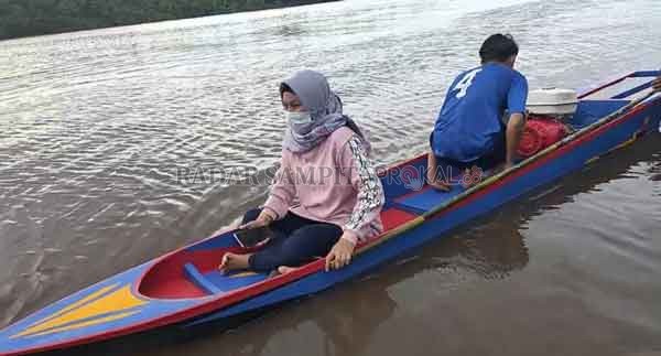 UNTUK LOMBA: Direktur Radar Sampit Siti Fauziah saat mencoba menaiki perahu ketinting, Sabtu (27/12).(YUNI/RADAR SAMPIT)