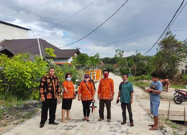 PANTAU : Lurah Tampang Tumbang Anjir Berjoaldi (batik coklat) memantau pengerjaan jalan lingkungan, tepatnya di Jalan Pinang I yang dibangun dengan menggunakan dana kelurahan, belum lama ini.(LURAH TAMPANG TUMBANG ANJIR FOR RADAR SAMPIT)