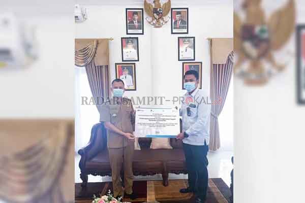 TERIMA PENGHARGAAN: Bupati Gumas Jaya S Monong menerima penghargaan dari PT PLN Unit Induk Wilayah Kalimantan Selatan dan Kalimantan Tengah, yang diberikan oleh Manajer PLN ULP Kuala Kurun Agung Darmawan, di rumah jabatannya, Selasa (19/1).(PROTOKOL FOR R