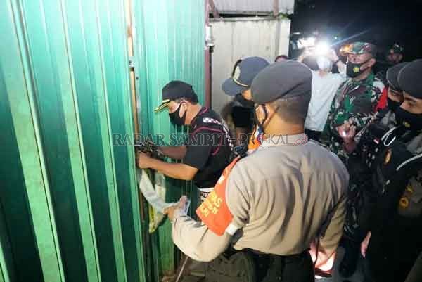 TINDAKAN TEGAS : Tim Gabungan Satgas Penanggulangan Covid-19 Kota Palangka Raya saat menyegel pintu masuk Tempat Hiburan Malam (THM) Plat D Karaoke di Jalan Tingang, Selasa , malam.(istimewa)