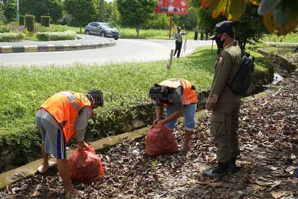 OPERASI YUSTISI : Masyarakat yang tak taat protokol kesehatan disanksi kerja sosial saat petugas menggelar razia masker di Bundaran Garuda – Jalan Bukit Keminting, Palangka Raya, Kamis (11/2) kemarin.(IST/RADAR PALANGKA)