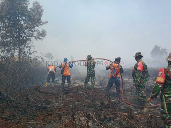 KARHUTLA : Karhutla di Kilometer 12 Jalan Pangkalan Bun-Kotawaringin Lama terus meluas. Petugas gabungan berupaya keras melakukan pemadaman.(RINDUWAN /RADAR PANGKALAN BUN )