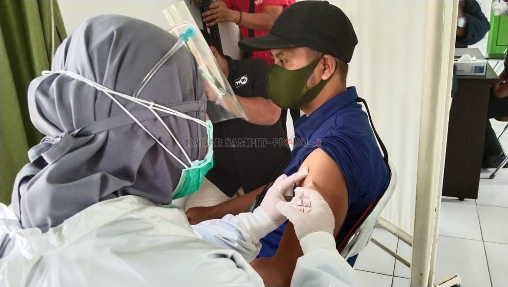 VAKSINASI COVID-19 : Ketua PWI Kotawaringin Barat Syamsudin yang merupakan Kepala Biro Radar Sampit, Pangkalan Bun saat mendapat suntikan vaksin Covid-19, di Puskesmas Pelingkau, Kelurahan Baru, Kecamatan Arut Selatan, Senin (8/3). (SLAMET HARMOKO/RADAR P