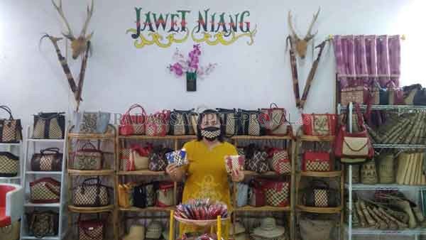 IDE KREATIF: Niang, pemilik galeri Jawet Niang membuat ide kreatif membuat masker dengan perpaduan anyaman rotan.(YUSHO/RADAR SAMPIT)
