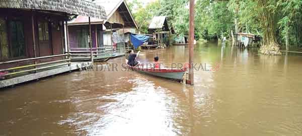 TERENDAM: Banjir di Kelurahan Marang, Kota Palangka Raya, membuat jalan menjadi sungai. Warga terpaksa menggunakan perahu untuk keluar rumah.(IST/RADAR SAMPIT)