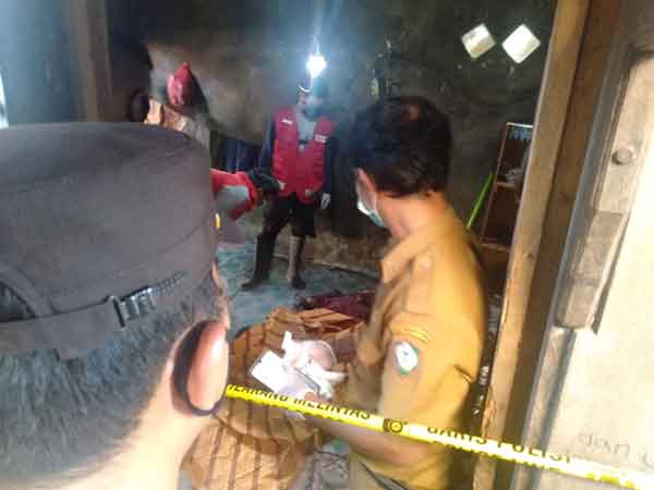 GEGER: Petugas Polsek Baamang saat mengidentifikasi jenazah Bahrul yang ditemukan tewas di rumahnya, Selasa (20/4).(FAHRY/RADAR SAMPIT)