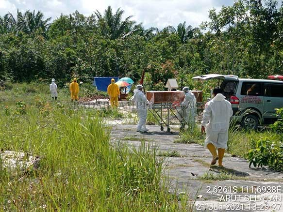 PEMAKAMAN: Petugas pemakaman saat menurunkan jenazah pasiesn Covid-19 untuk dimakamkan. Saat ini jumlah warga terkonfirmasi positif Covid-19 Kobar terus meningkat, sedangkan di sisi lain ruang isolasi di rumah sakit kian terbatas. (FOTO: ISTIMEWA/RADAR SA