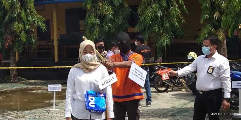 PEMBUNUHAN: Tersangka saat memperagakan adegan memukulkan kayu ke kepala korban. (ALWANDI/RADAR SAMPIT)