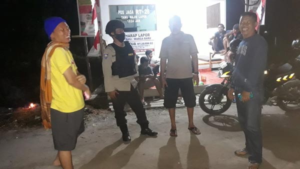 PATROLI: Personel Polsek Baamang mendatangi warga yang melaksanakan ronda malam di Jalan Tidar IV, Kecamatan Baamang, Sampit, Rabu (11/8) malam. (IST/RADAR SAMPIT)
