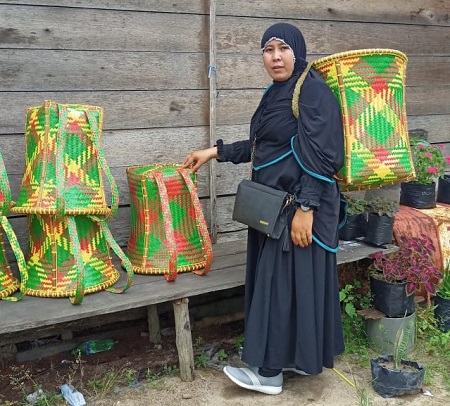 BUTUH PATEN: Tampak seorang warga saat menggunakan produk hasil kerajinan masyarakat Seruyan. Para pengrajin ini perlu mendapat bantuan untuk mengurus paten atas hasil kerajinan mereka.