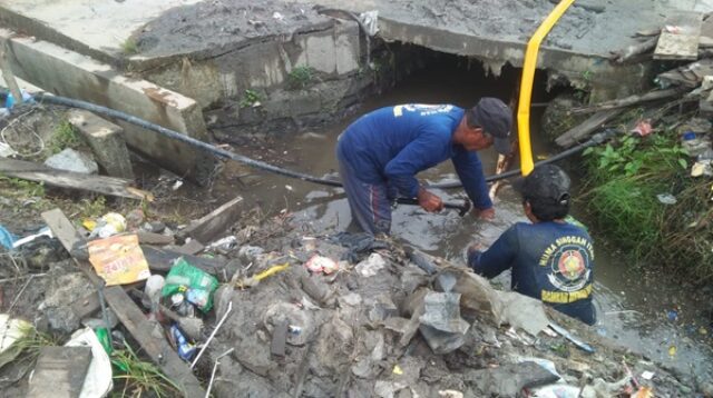 DRAINASE: Personel Balakar Huma Singgah Itah Mendawai saat membersihkan sampah di drainase Jalan Ahmad Yani, Kelurahan Baru, Sabtu (18/11/2023). (SULISTYO/RADAR PANGKALAN BUN)