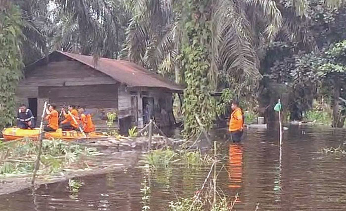 Personel BPBD Dumai melakukan penyisiran permukiman masyarakat  di Kelurahan Guntung, Kecamatan Medang Kampai, Kota Dumai yang terdampak banjir, Selasa (2/1/2004).