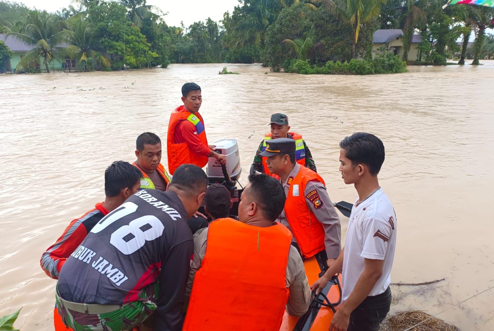 Kapolsek Kuantan Mudik AKP Hendra Setiawan dan jajaran bersama Tokoh Pemuda Gunung Toar Radiansyah menaiki perahu karet untuk evakuasi korban banjir di Petapahan, Gunung Toar, Rabu (3/1/2024).