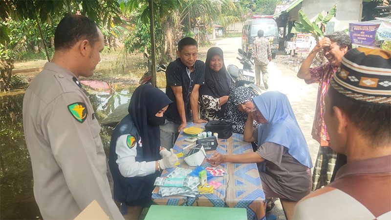 Kasidokkes Polres Kampar Aipda Eka Putra memimpin tim medis dalam memberikan layanan kesehatan kepada para korban banjir di Desa Tanjung Rambutan, Kecamatan Kampar.