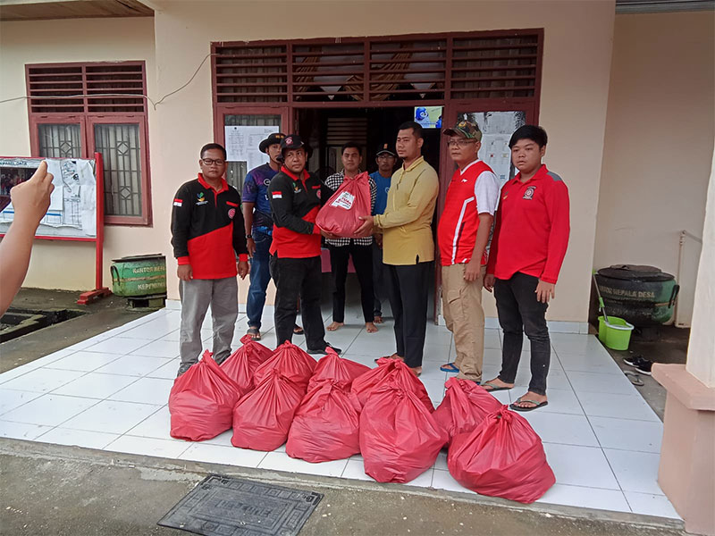 Pegawai Dinsos P3A dan anggota Tagana Rohul menyalurkan bantuan ratusan nasi bungkus kepada perwakilan Pemerintah Desa Kepenuhan Timur untuk disalurkan kepada warga yang terdampak banjir .