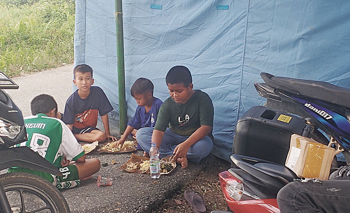 anak-anak warga Dusun Simpang Kualo, Kelurahan Pangkalankerinci Kota, Kecamatan Pangkalankerinci menikmati santapan makan siang di tenda pengungsian yang didirikan Pemerintah Kabupaten Pelalawan.