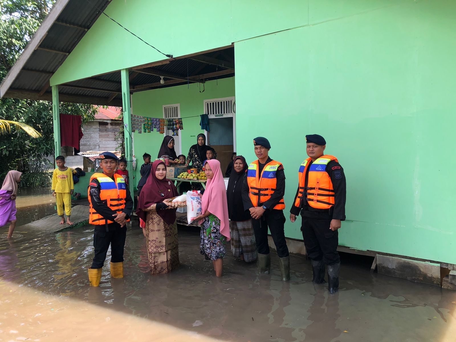 Personel Batalyon B Satbrimobda Riau menyerahkan bantuan sembako kepada masyarakat tertimpa musibah banjir di Rokan Hilir, Sabtu (6/1/2024).