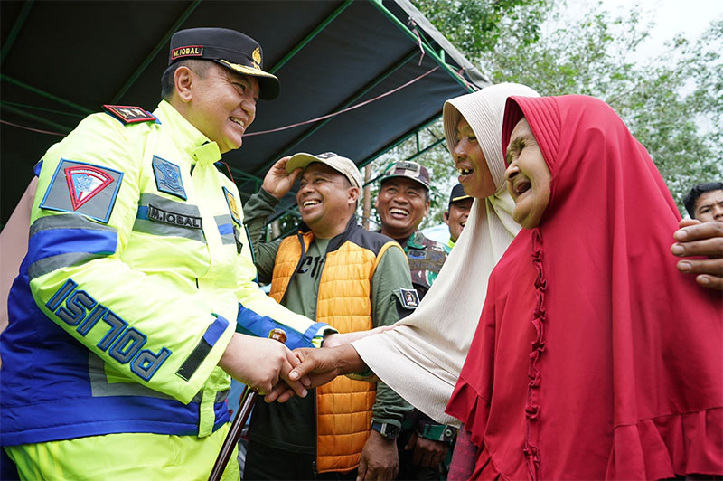 Kapolda Riau Irjen Pol Mohammad Iqbal bersalaman dengan emak-emak di Pelalawan yang menjadi korban banjir. Dalam kesempatan itu Irjen Iqbal turut memberikan bantuan paket sembako, Sabtu (6/1/2024)