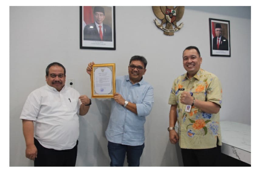 Kabid HI dan JSTK Disnakertrans Pitter Bonis (kanan) menyerahkan piagam penghargaan kepada PTPN IV Regional V yang diwakili SEVP Business Support Muhammad Zulham Rambe (tengah).
