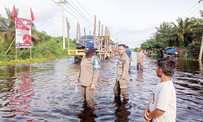 Personel Satpol PP Pelalawan ikut mengawasi aktivitas penyeberangan kendaraan di Jalan Lintas Timur Sumatera, Desa Kemang, Kecamatan Pangkalan Kuras, Kabupaten Pelalawan, Senin (8/1/2024).