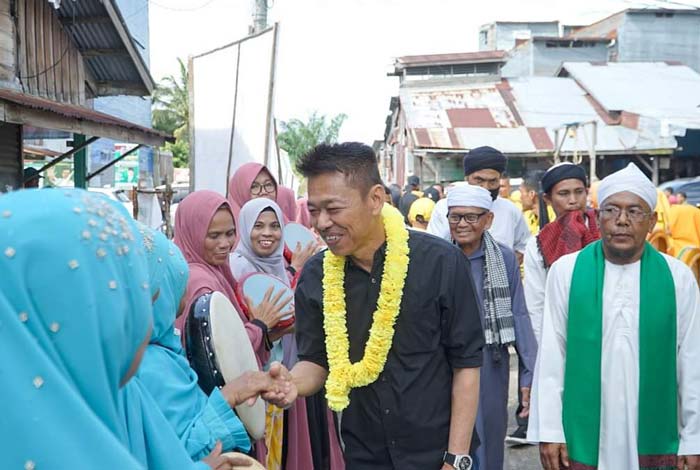 Bupati Rohil menyalami warga saat datang ke tempat acara hiburan rakyat di Jalan Pembangunan, Kelurahan Bagan Barat, Sabtu (6/1)