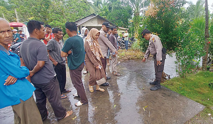 Personel Polsek Sungai Apit menunjuk parit tempat korban Omar Al-Faruq hanyut di Kampung Teluk Masjid, Kecamatan Sungai Apit, Siak, Selasa (9/1/2024).