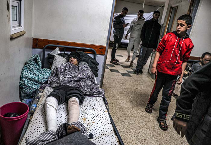 Seorang pemuda yang terluka terbaring di tempat tidur di kamp darurat di area Rumah Sakit Eropa di Khan Yunis di Jalur Gaza Selatan, belum lama ini.