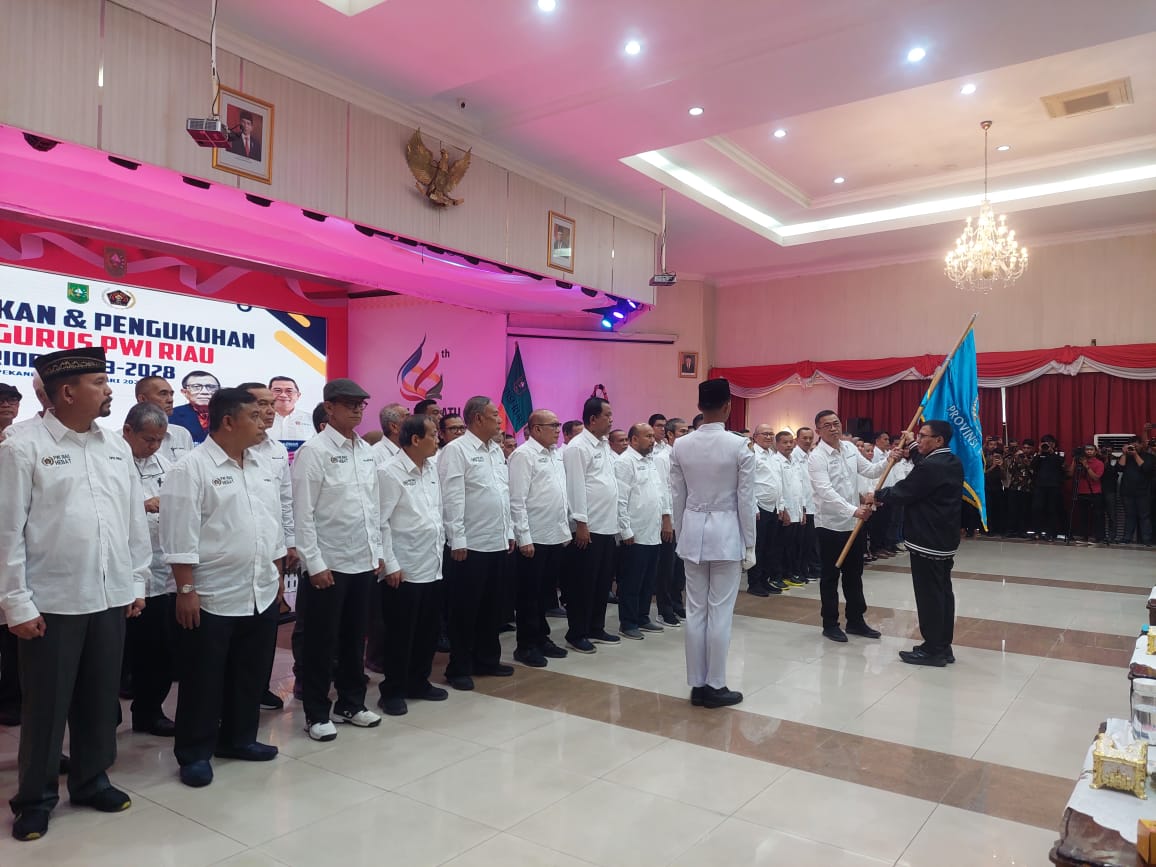 Ketua PWI Riau Raja Isyam Azwar menerima bendera pataka dari Ketua PWI Pusat Hendry Ch Bangun saat pelantikan pengurus PWI Riau di Balai Serindit, Jalan Diponegoro, Pekanbaru, Kamis (11/1/2024).