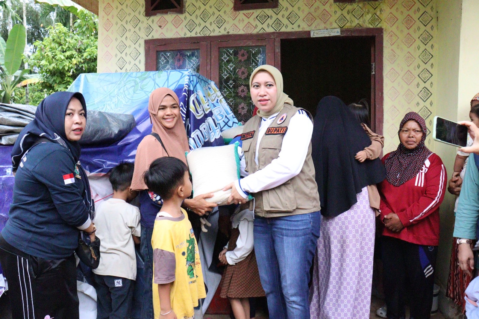 Bupati Inhu, Rezita Meylani Yopi SE menyerahkan bantuan kepada salah seorang warga yang terdampak banjir, Kamis (11/1/2024).