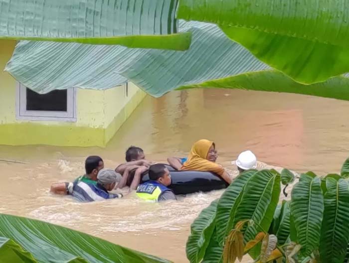 Petugas Polres Inhu Bripka Donni bersama beberapa orang warga saat melakukan evakuasi terhadap Ngadiah (65) yang terjebak banjir di rrumahnya di Desa Wonosari, Inhu, beberapa waktu lalu.
